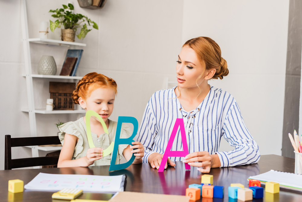 Adult and child holding alphabet letters