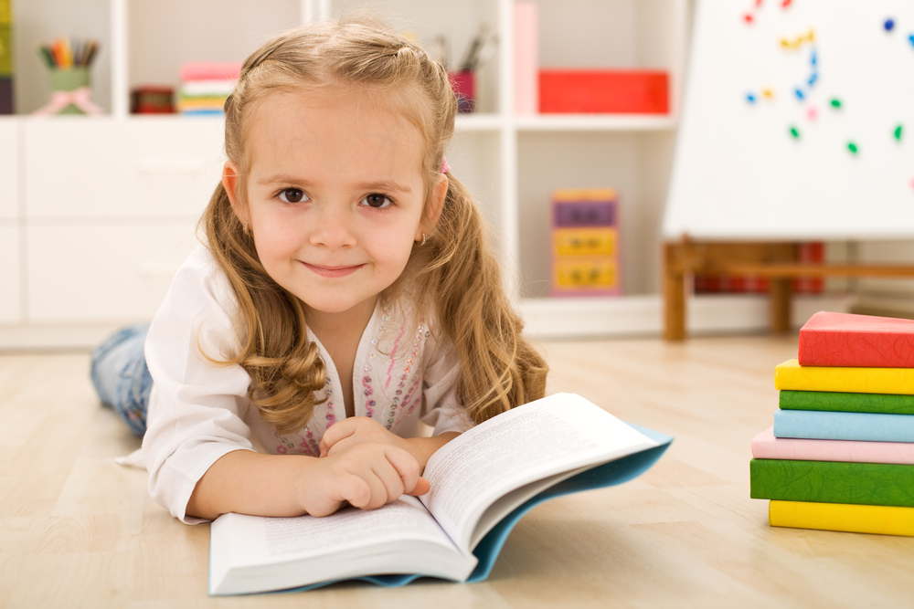 Girl practicing reading on floor