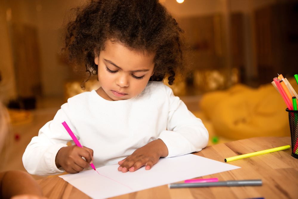 Girl working on number recognition exercises at table