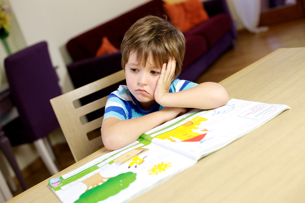 Bored little child student at home