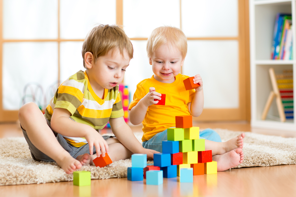 Kids playing block toys in playroom at nursery