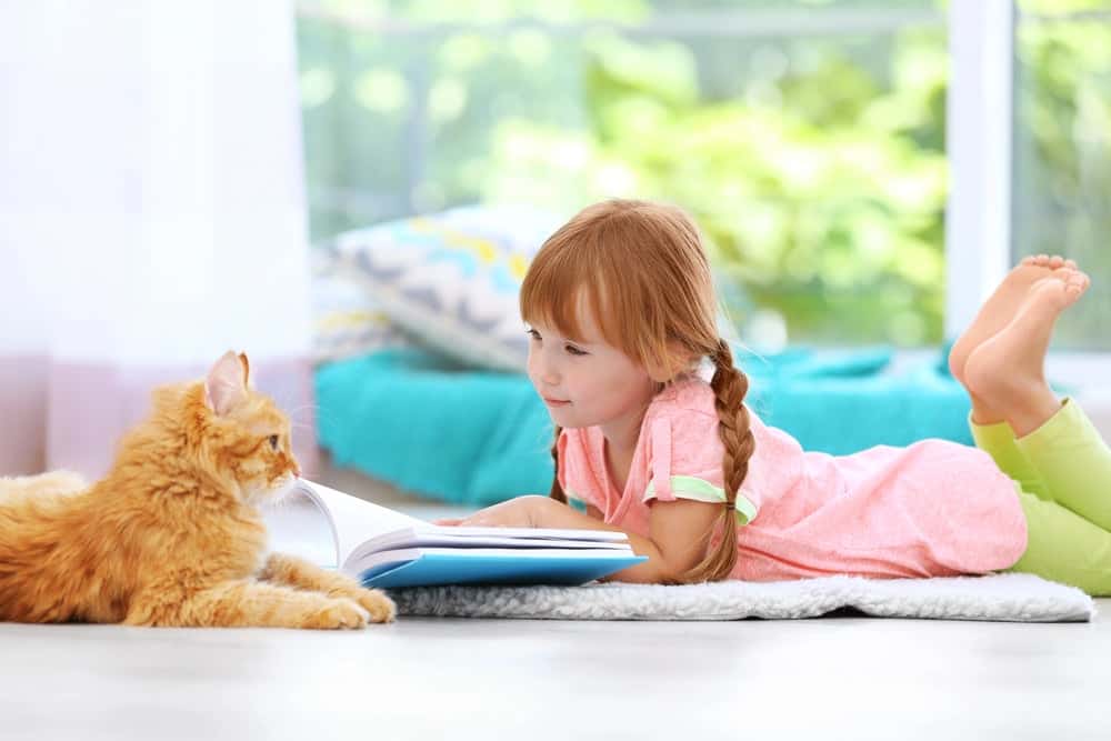 kid reading with her cat