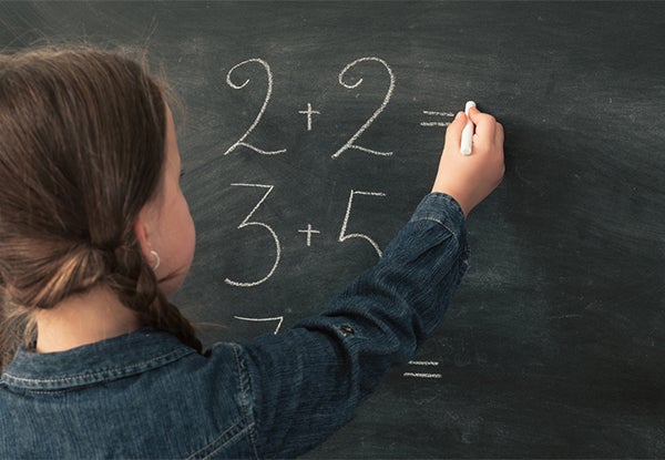 Kid doing math on a chalkboard