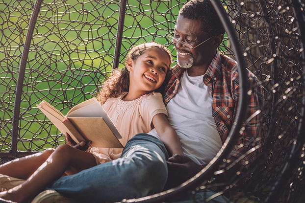 Dad reading to young daughter to teach her compound words for kids
