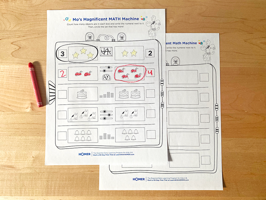 Completed math printables with crayon on table