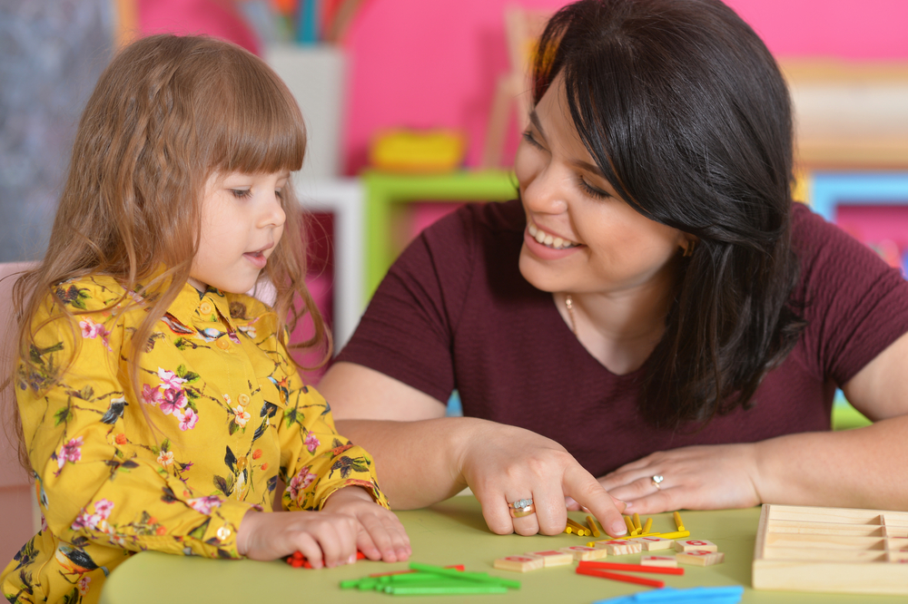 Teacher working with child to learn spelling