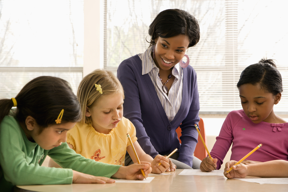Teacher playing spelling games with three kids