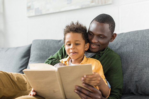 Young kid and dad working on kindergarten reading skills