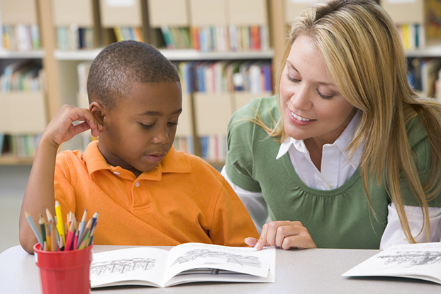 teacher helping kid with his kindergarten reading