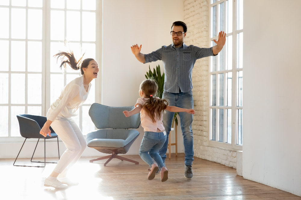 Family dancing together during indoor play when it's too hot outside