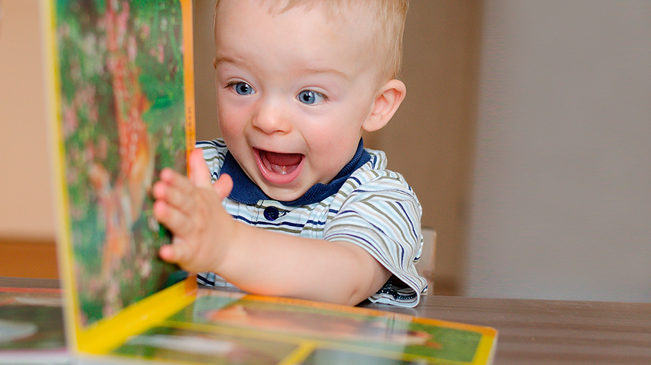 Beaming child reading book about animals