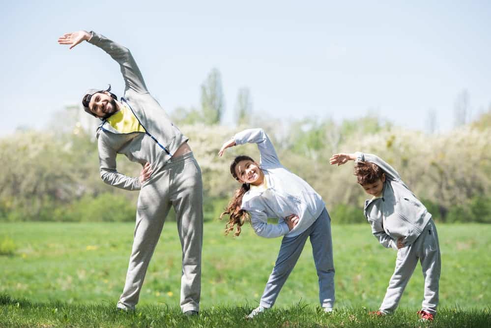 Dad showing stretching techniques to  his kids as a calming strategies for kids