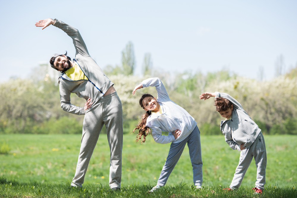Dad showing stretching techniques to his kids as a calming strategies for kids