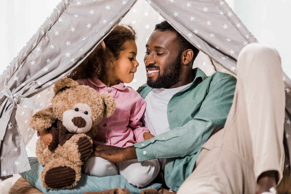 Dad playing in a fort with daughter