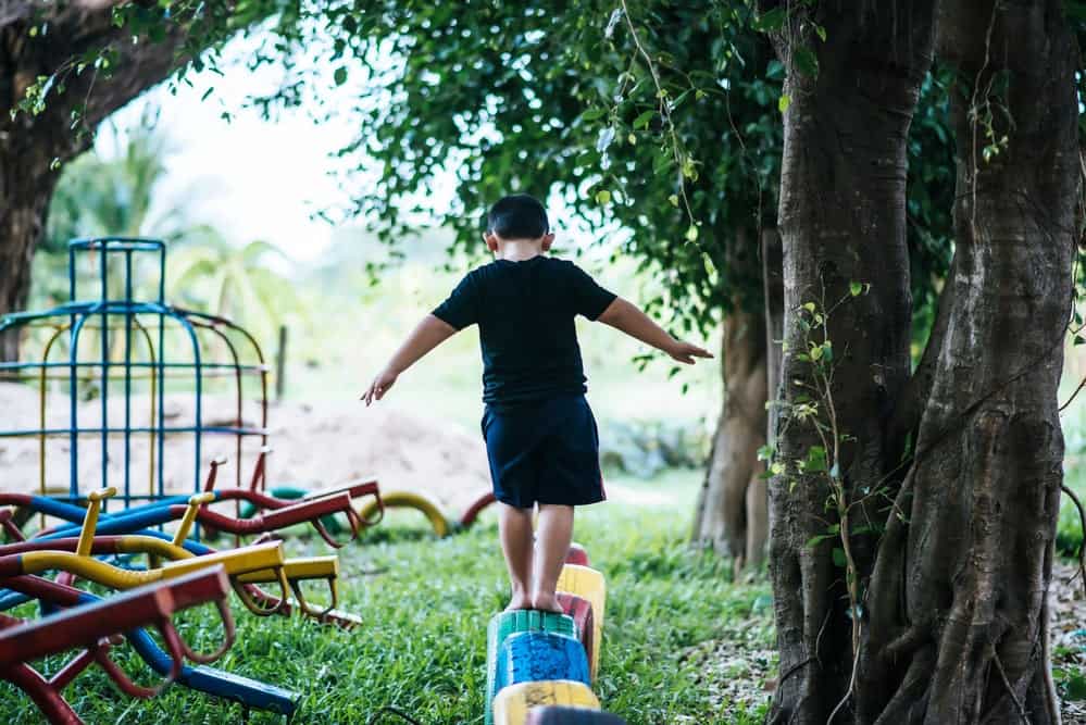 Young kid balancing on outdoor playground 