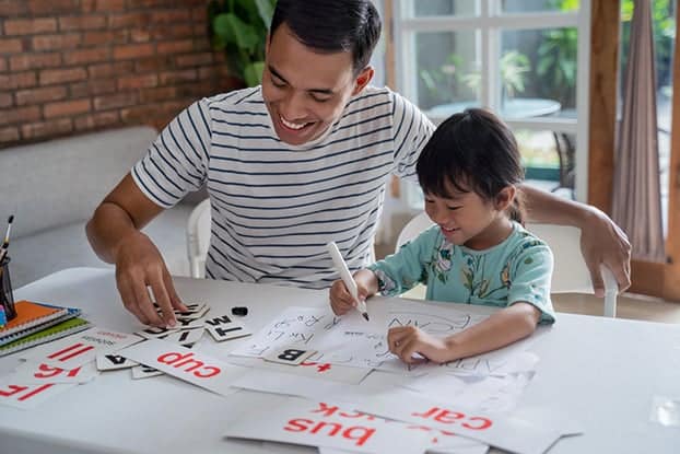 father teaching letter to her daughter at home