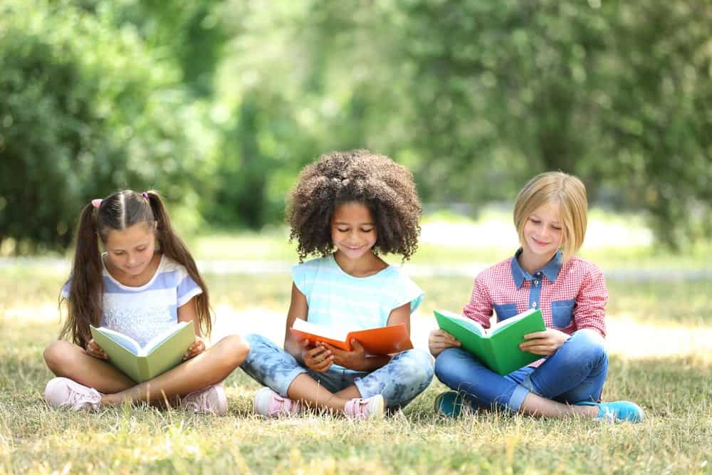 A group of kids reading outside