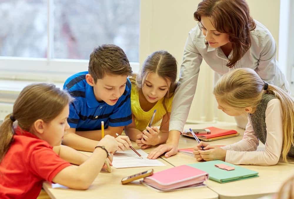 teacher helping her students