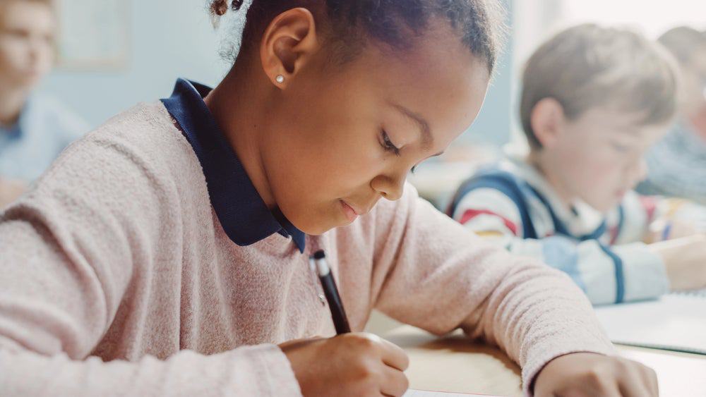 young girl practicing spelling words