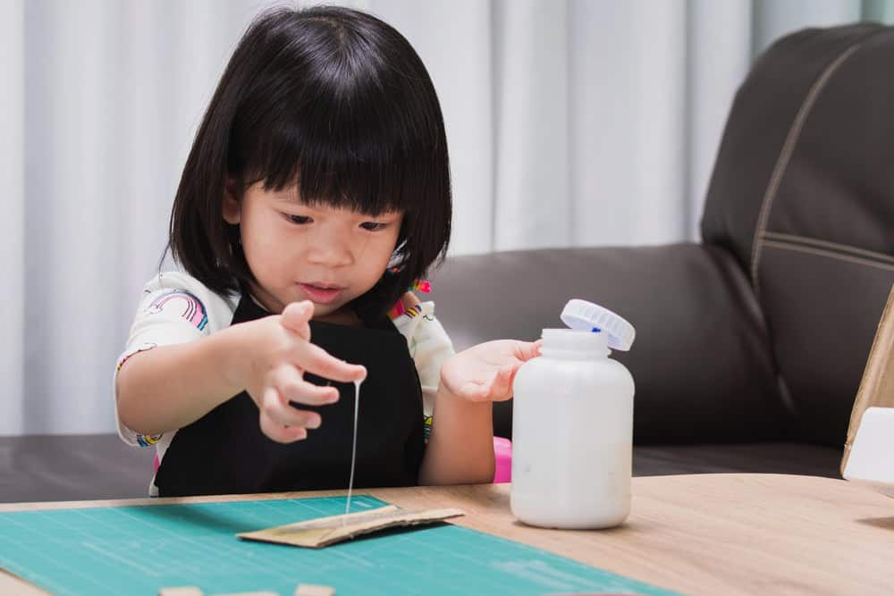 kid playing with glue
