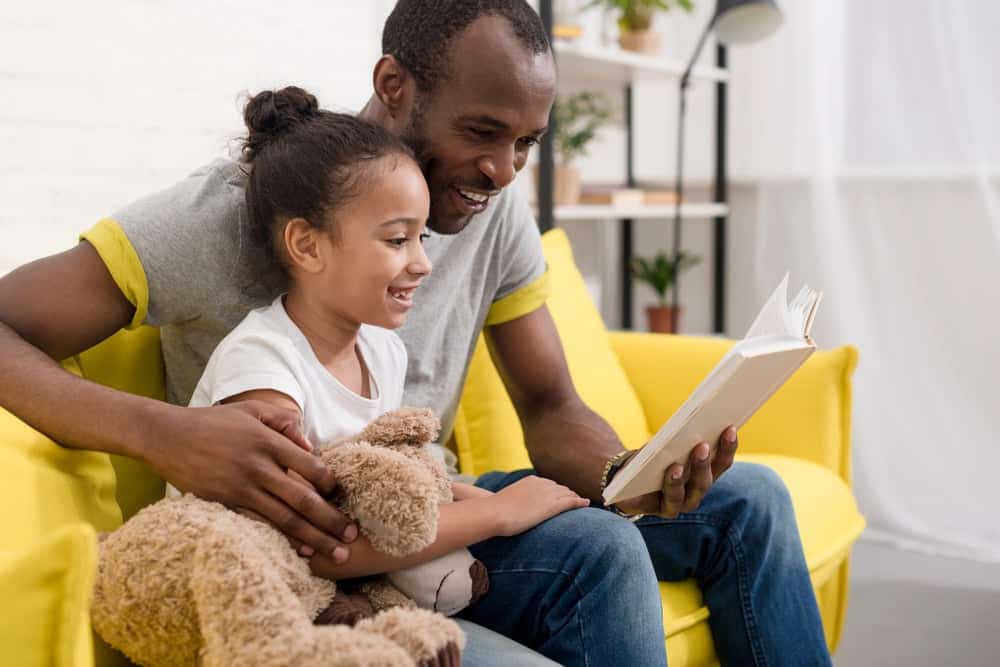 Dad reading his daughter confidence quotes for kids
